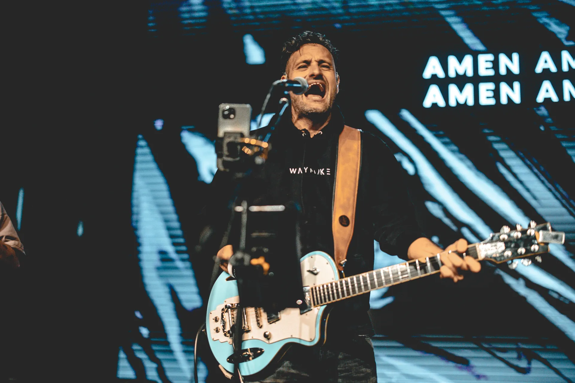 Angelo Arcifa singt mit elektrischer Gitarre auf der Bühne