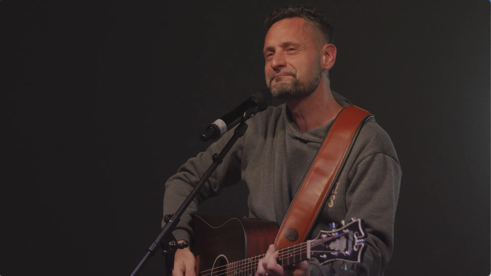 Angelo Arcifa mit Akustikgitarre am Mikrofon